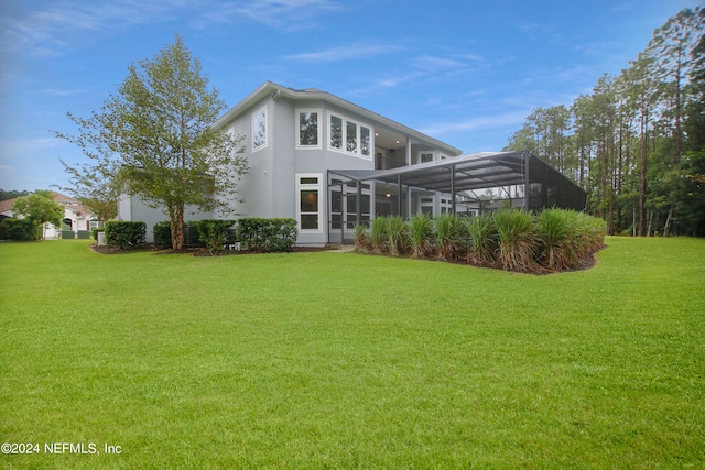 back of house featuring glass enclosure and a yard