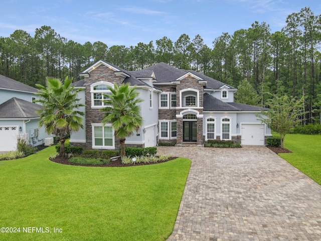 view of front of property with central AC unit, a front yard, and a garage