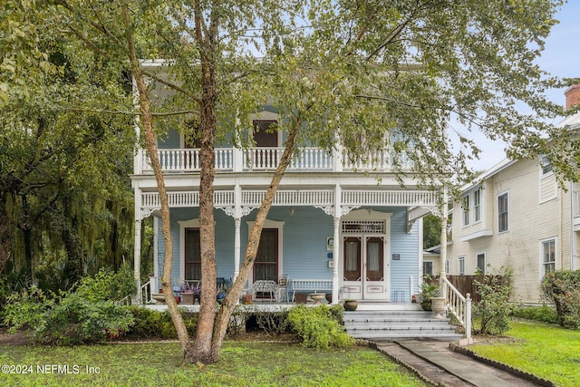 view of front of property featuring ceiling fan, a front yard, and a porch