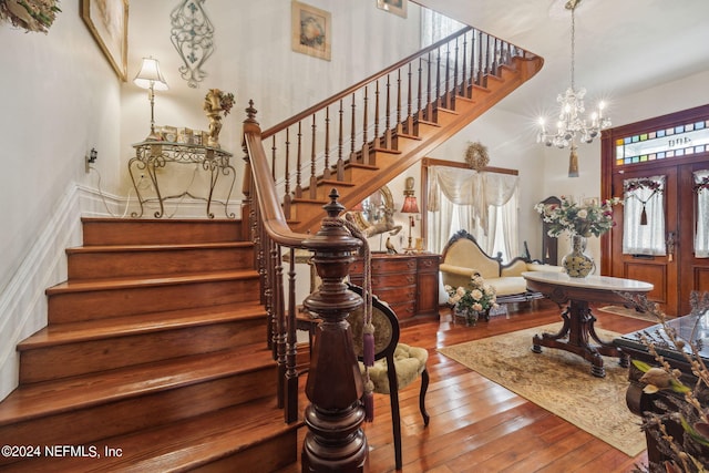 foyer with an inviting chandelier, french doors, and hardwood / wood-style flooring