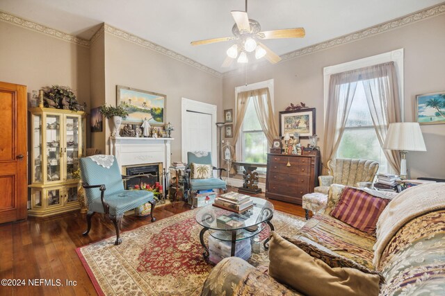 living room featuring ceiling fan, dark hardwood / wood-style floors, and crown molding