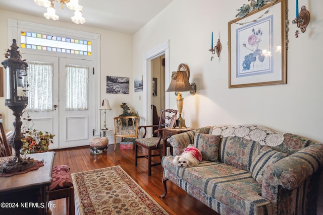 living room with wood-type flooring, french doors, and a notable chandelier