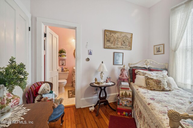 bedroom with wood-type flooring and connected bathroom