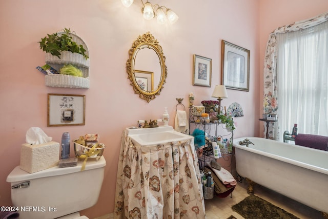 bathroom featuring sink, a tub to relax in, toilet, and hardwood / wood-style flooring