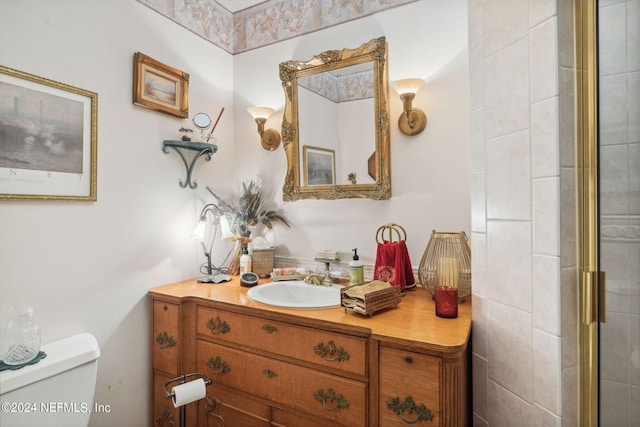 bathroom featuring vanity, toilet, and a shower with door