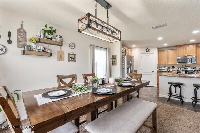 dining area featuring a textured ceiling and dark hardwood / wood-style floors