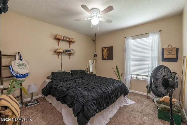 carpeted bedroom featuring ceiling fan and a textured ceiling