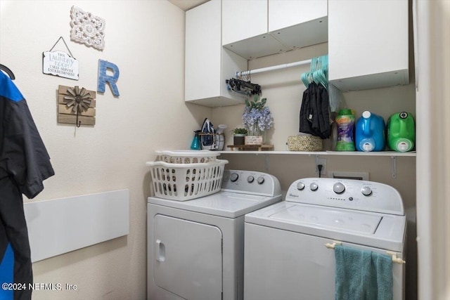 laundry room featuring washer and clothes dryer and cabinets