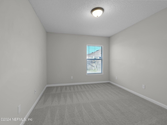 carpeted spare room featuring a textured ceiling