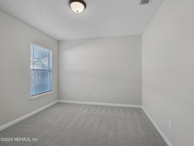 unfurnished room featuring carpet flooring and a textured ceiling