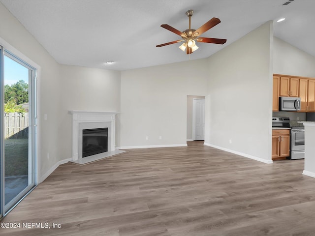 unfurnished living room with light hardwood / wood-style floors, high vaulted ceiling, and ceiling fan