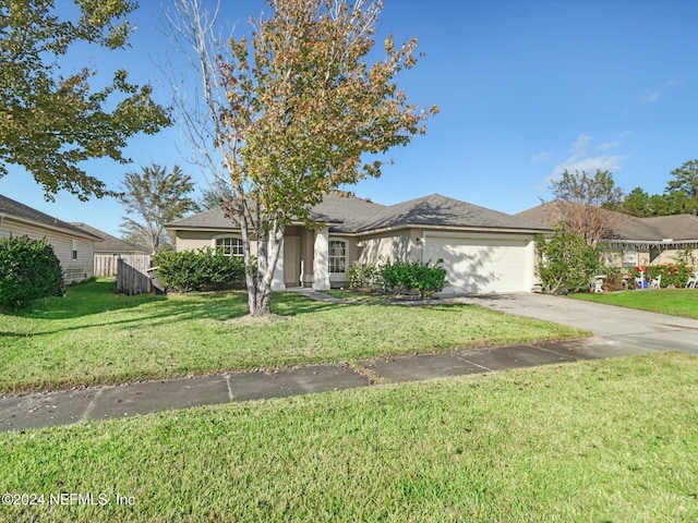 view of front of home with a front yard and a garage