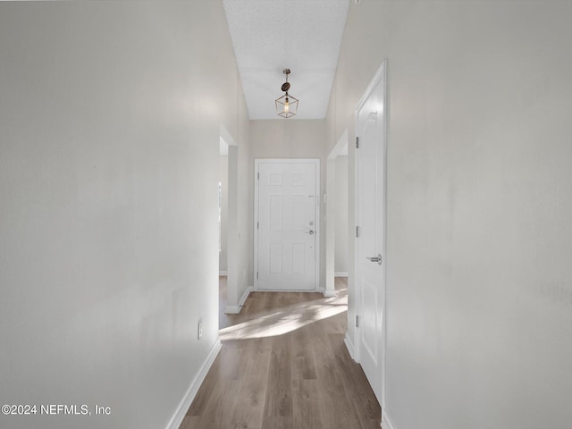 hallway with wood-type flooring and a textured ceiling