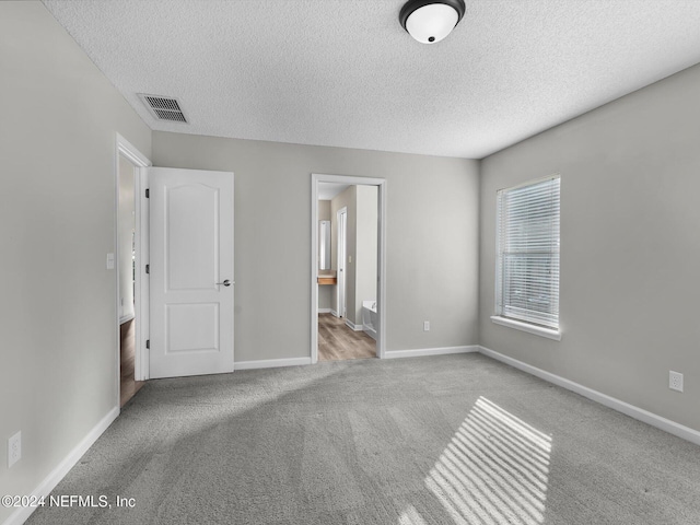 unfurnished bedroom with light carpet and a textured ceiling