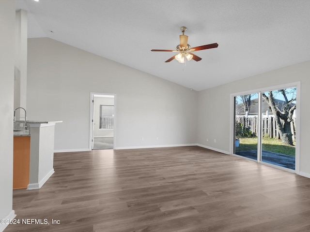 unfurnished living room with high vaulted ceiling, ceiling fan, dark wood-type flooring, and sink