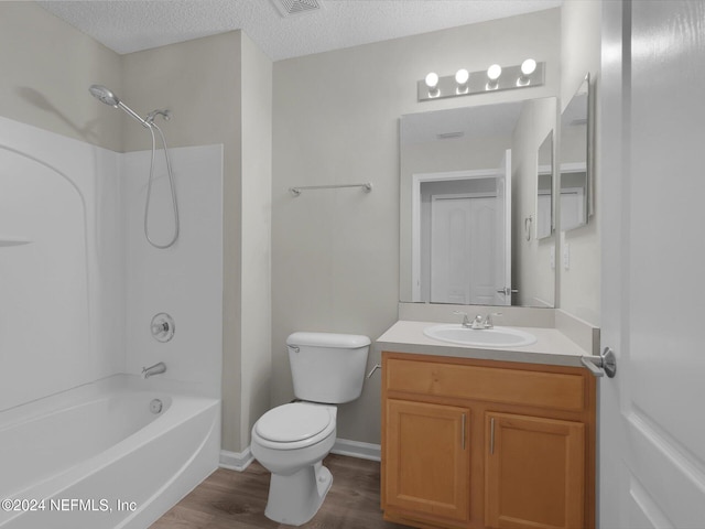 full bathroom featuring bathing tub / shower combination, a textured ceiling, toilet, vanity, and hardwood / wood-style flooring