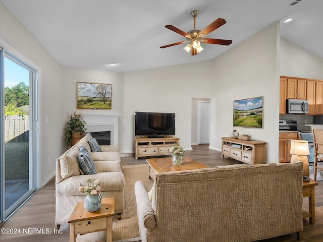 living room with ceiling fan, lofted ceiling, and light hardwood / wood-style flooring