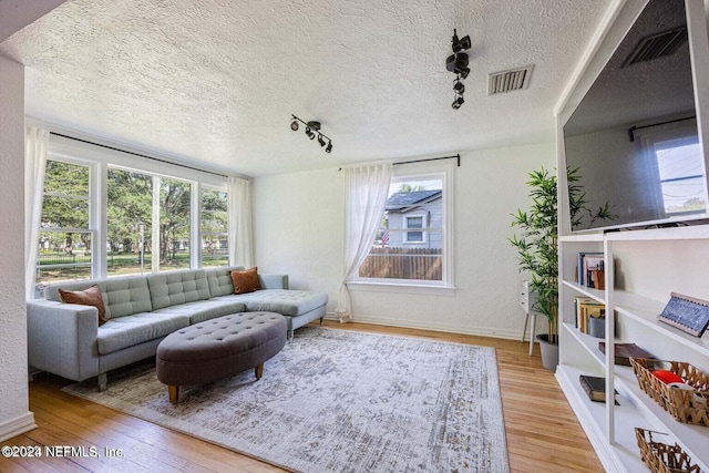 living room featuring light hardwood / wood-style floors and a textured ceiling