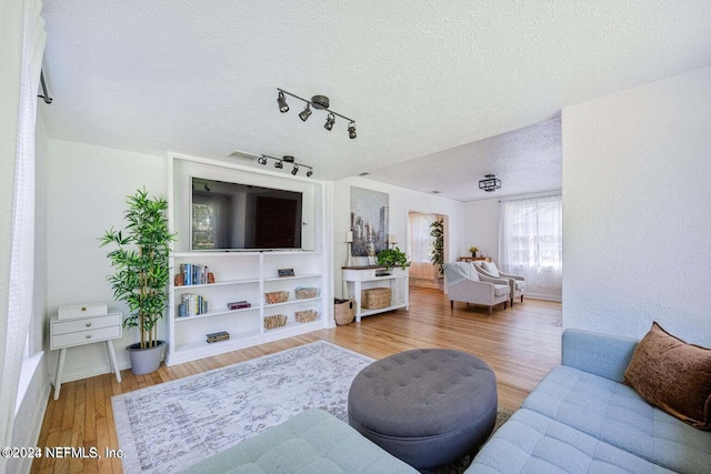 living room with hardwood / wood-style flooring and a textured ceiling