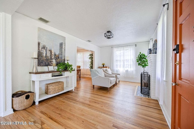 sitting room featuring light hardwood / wood-style flooring and a textured ceiling