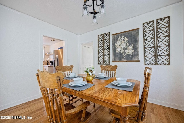 dining area with a chandelier and light hardwood / wood-style flooring