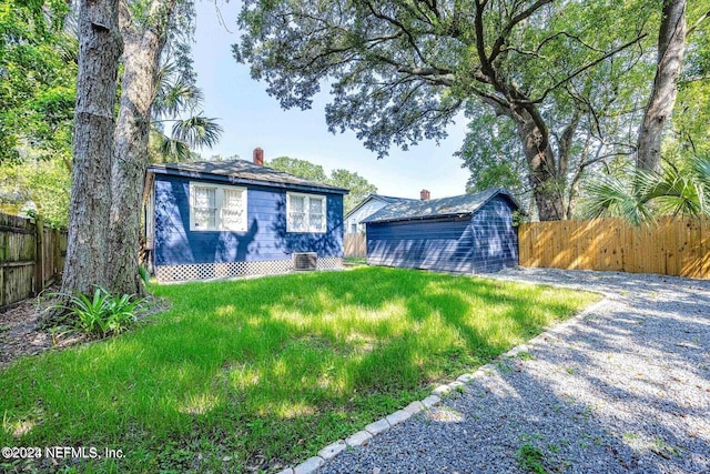 view of front of home with central air condition unit and a front lawn