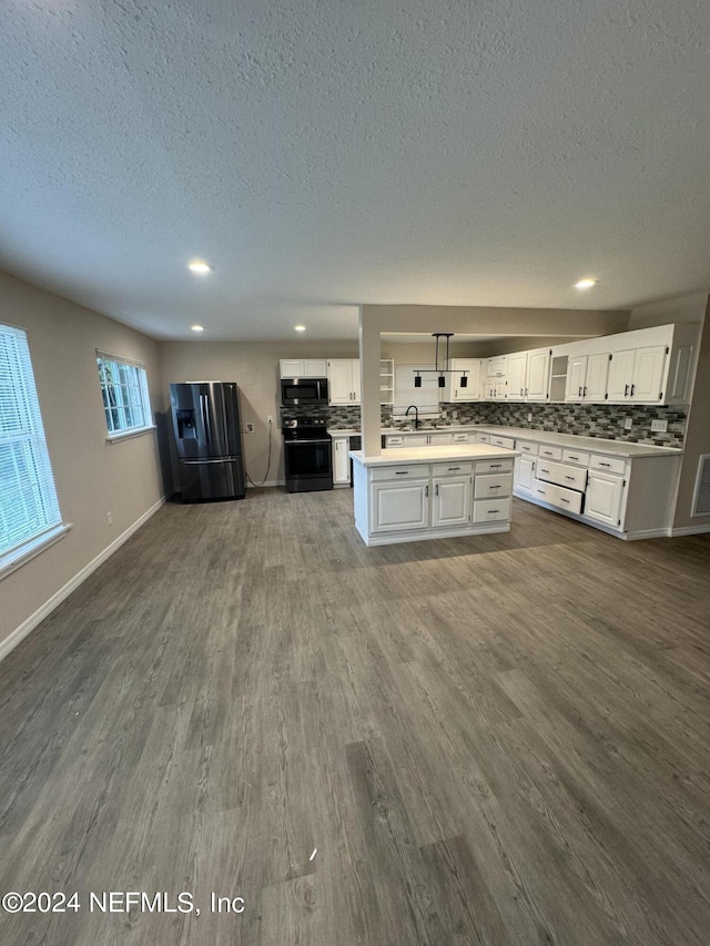 kitchen with a center island, dark hardwood / wood-style floors, tasteful backsplash, white cabinets, and appliances with stainless steel finishes