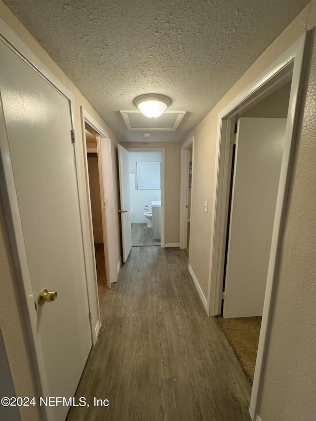 hall featuring hardwood / wood-style flooring and a textured ceiling