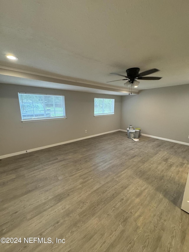 empty room featuring ceiling fan, hardwood / wood-style flooring, and a healthy amount of sunlight