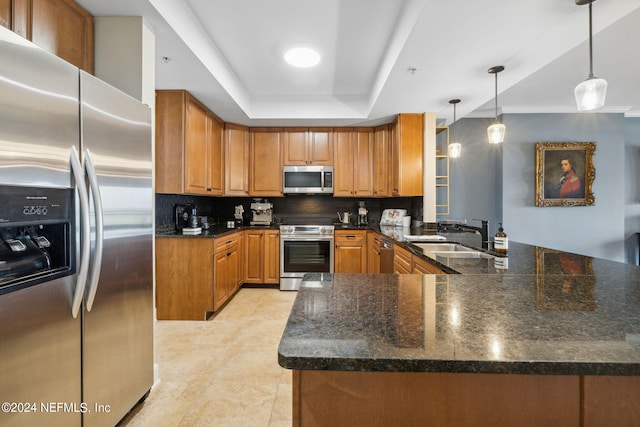 kitchen featuring kitchen peninsula, decorative backsplash, stainless steel appliances, sink, and decorative light fixtures