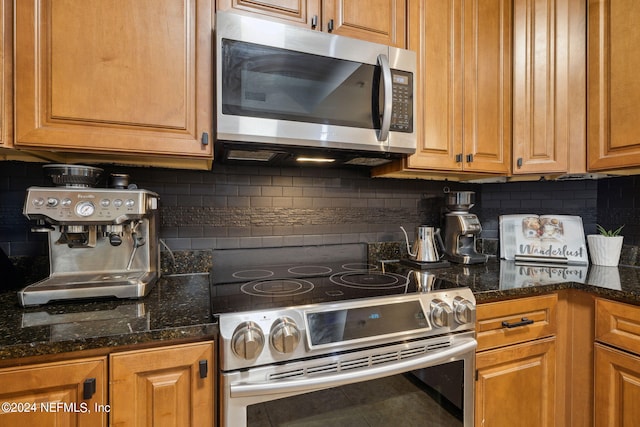 kitchen featuring dark stone counters, decorative backsplash, and stainless steel appliances