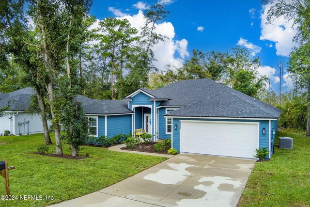 single story home featuring cooling unit, a front yard, and a garage