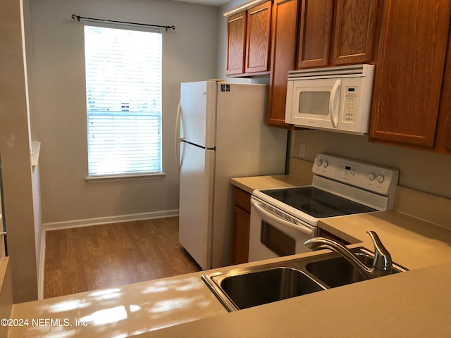 kitchen with sink, hardwood / wood-style floors, and white appliances