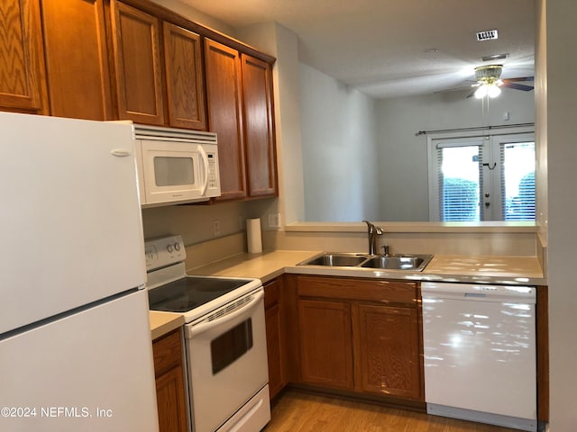 kitchen featuring light wood-type flooring, a textured ceiling, sink, white appliances, and ceiling fan