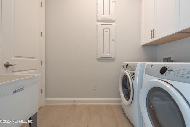 clothes washing area featuring cabinets, washing machine and dryer, and sink