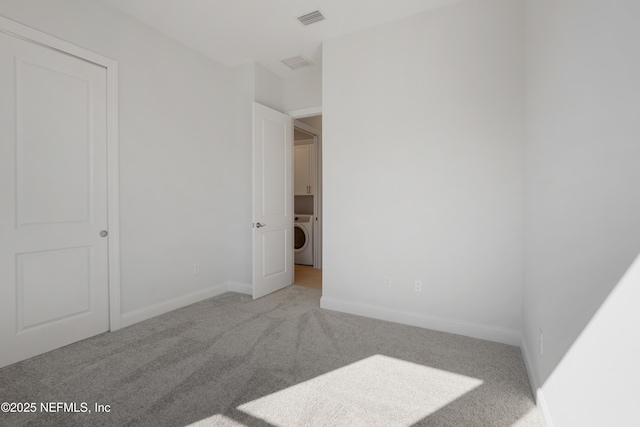 bedroom featuring light colored carpet and washer / dryer