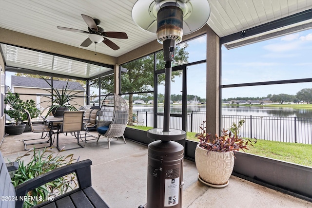 sunroom / solarium with a water view and ceiling fan