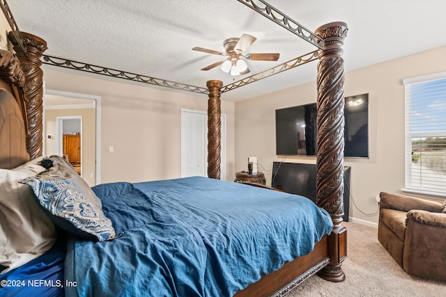 carpeted bedroom featuring ceiling fan and a textured ceiling