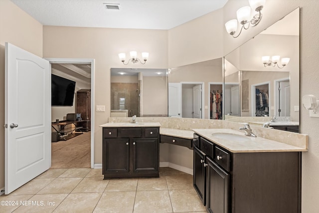 bathroom with an inviting chandelier, tile patterned floors, a shower with door, and vanity