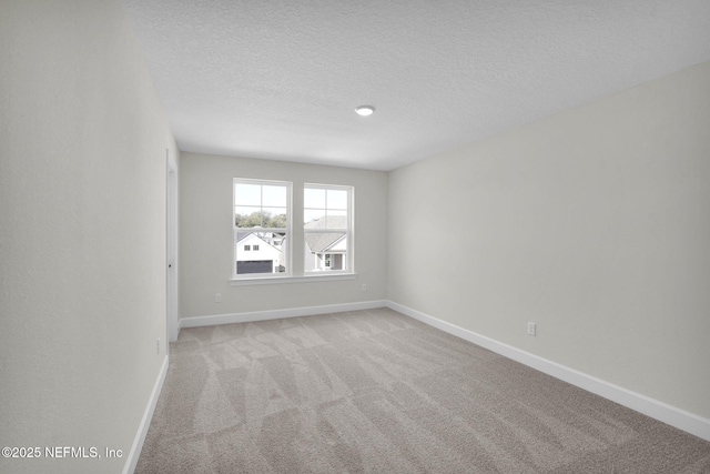 carpeted spare room featuring a textured ceiling