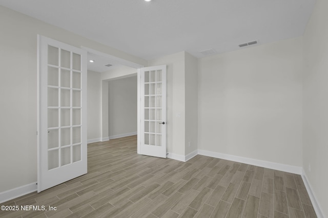 unfurnished room featuring light hardwood / wood-style floors and french doors