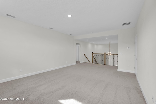 carpeted spare room with a notable chandelier