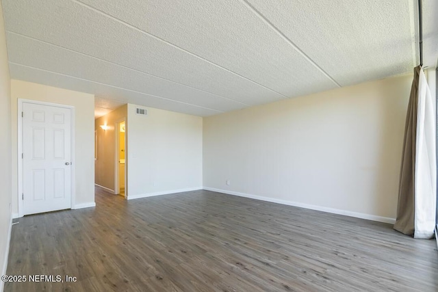 spare room with a textured ceiling and dark hardwood / wood-style floors