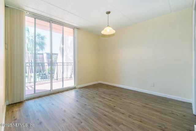 empty room with dark hardwood / wood-style flooring and floor to ceiling windows