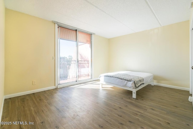 bedroom featuring dark wood-type flooring and expansive windows