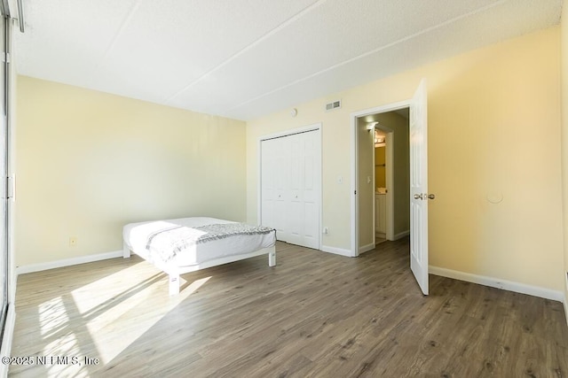 unfurnished bedroom with a closet and wood-type flooring