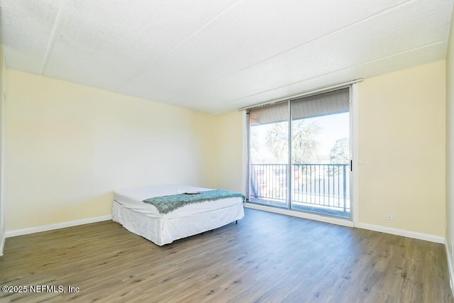 unfurnished bedroom featuring hardwood / wood-style flooring and access to outside