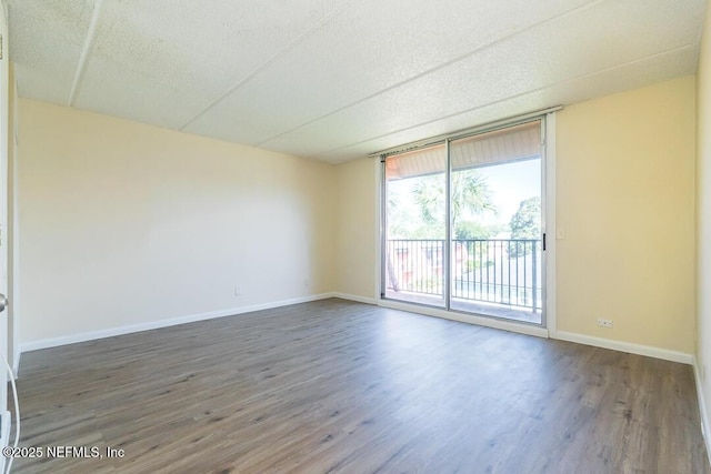 spare room featuring expansive windows and dark hardwood / wood-style flooring