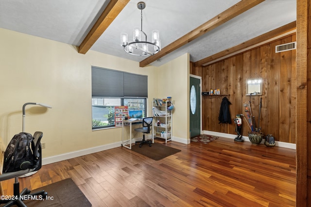 office area featuring wood walls, wood-type flooring, an inviting chandelier, and lofted ceiling with beams