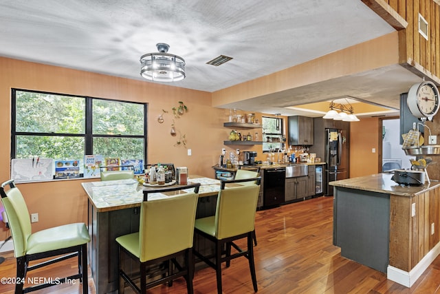 dining space with hardwood / wood-style floors and a textured ceiling